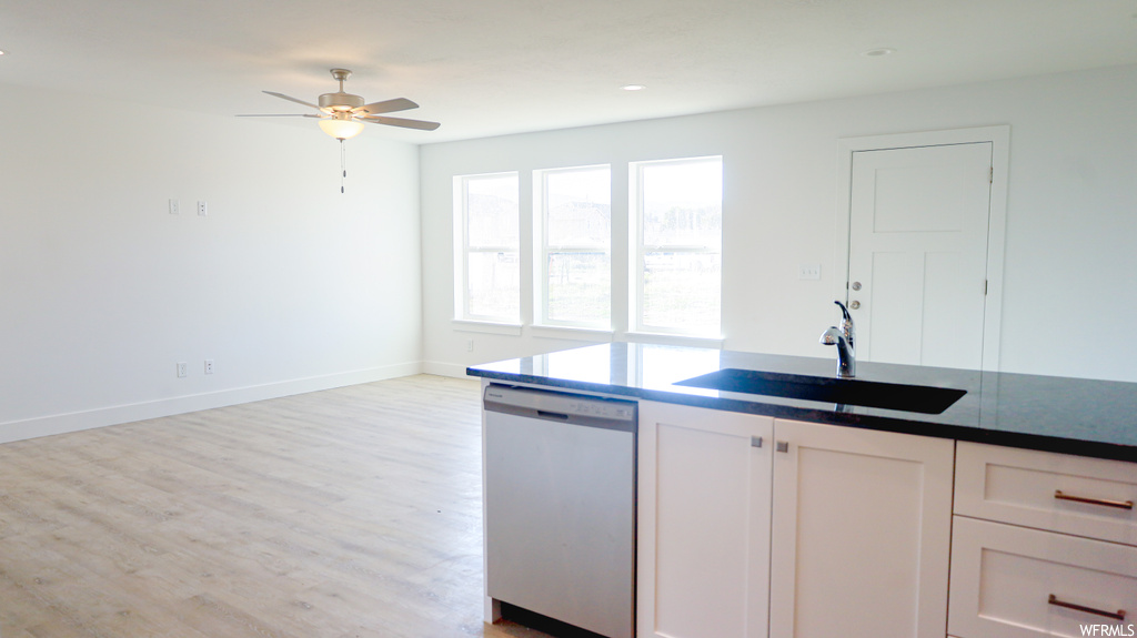 Kitchen featuring dishwasher, white cabinets, washbasin, ceiling fan, and light hardwood floors