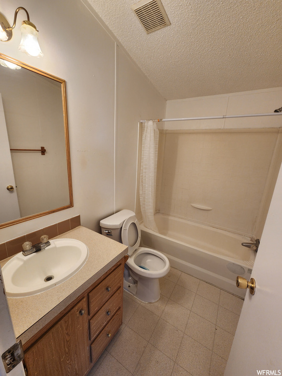 Full bathroom with tile floors, oversized vanity, a textured ceiling, shower / bath combination with curtain, and toilet