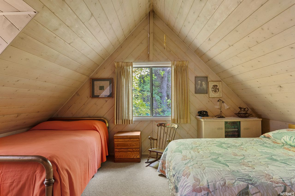 Carpeted bedroom featuring wooden walls, wood ceiling, and lofted ceiling