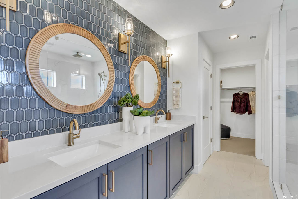 Bathroom featuring tasteful backsplash, tile flooring, and dual bowl vanity