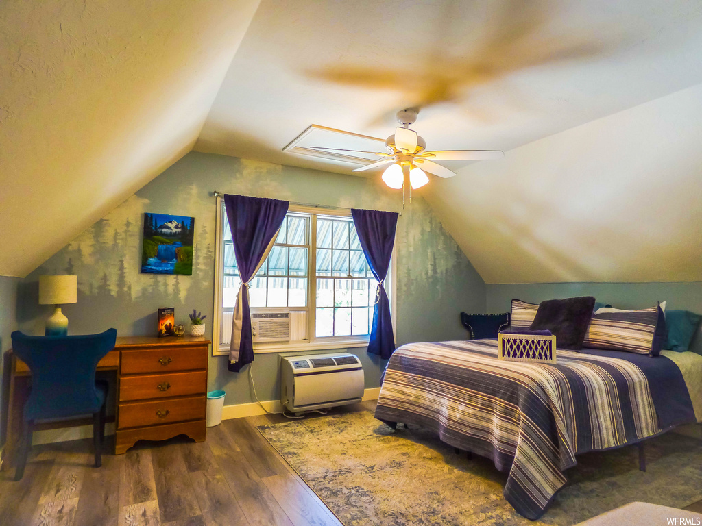 Hardwood floored bedroom with vaulted ceiling and ceiling fan