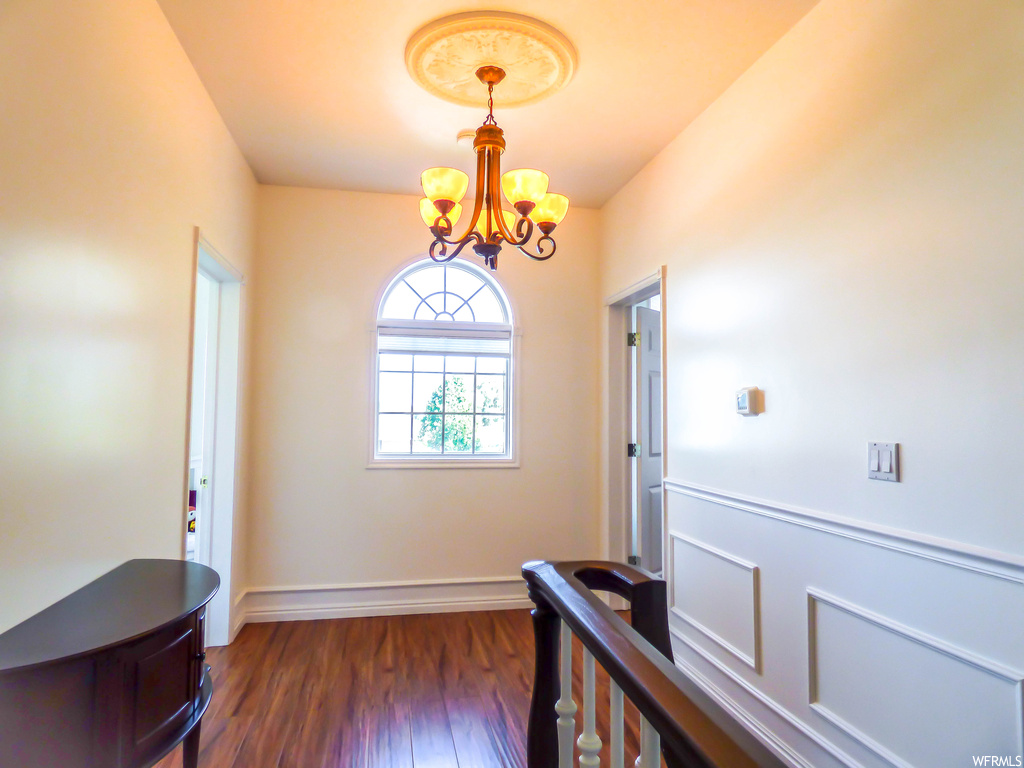 Hardwood floored entryway with a chandelier