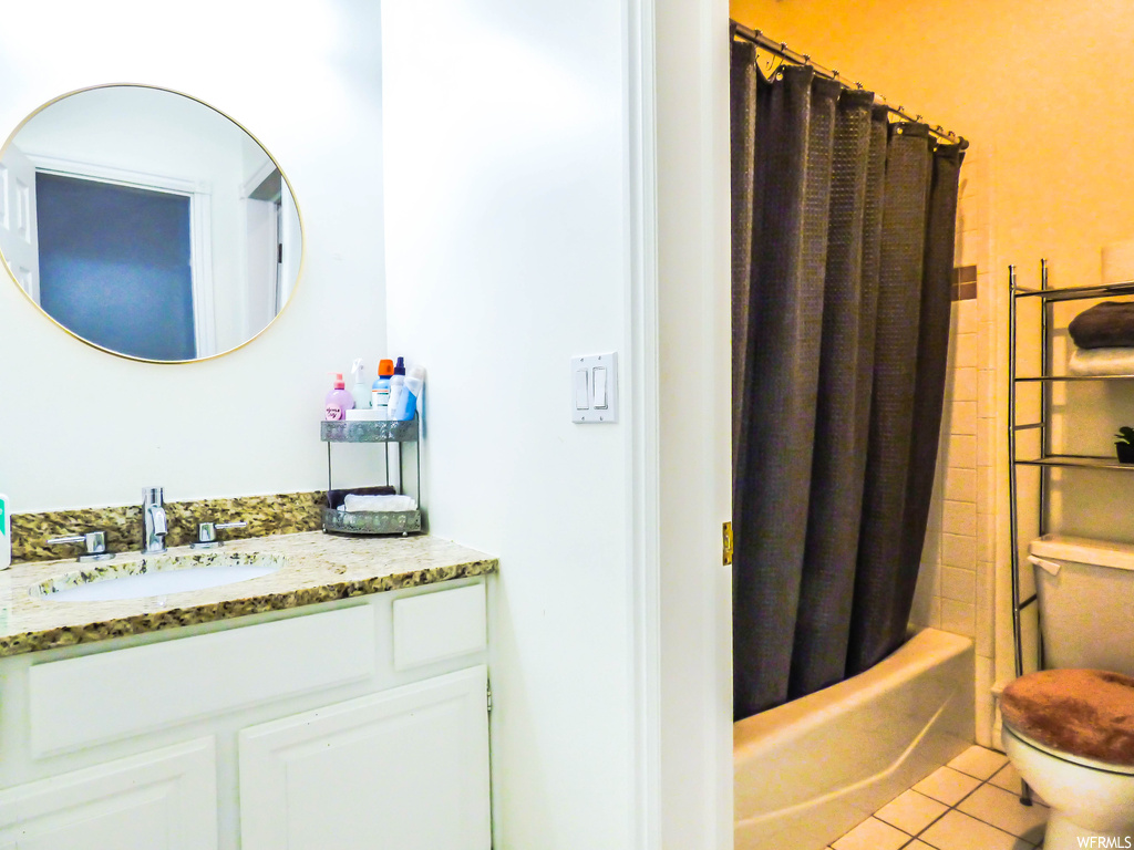 Full bathroom featuring shower / bath combo, vanity, tile flooring, and toilet