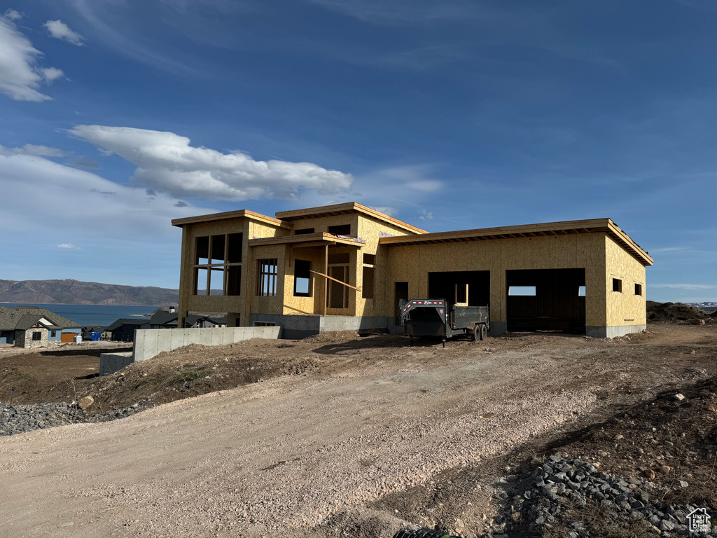 Unfinished property with a mountain view and a garage