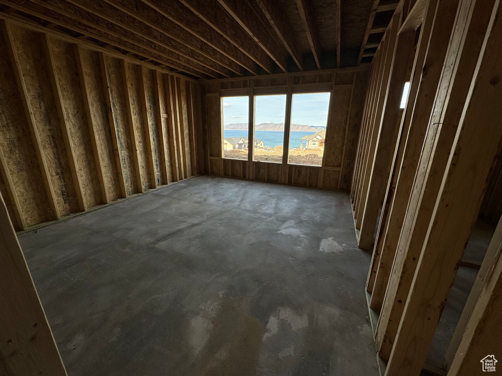 Unfurnished room featuring concrete flooring and a water view