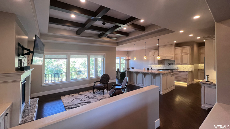 Interior space featuring coffered ceiling, ceiling fan, and beam ceiling