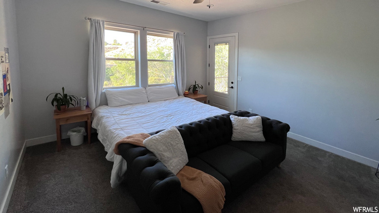 Bedroom featuring access to exterior, dark colored carpet, and ceiling fan