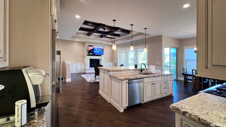 Kitchen featuring coffered ceiling, a kitchen island with sink, dark hardwood floors, dishwasher, and sink