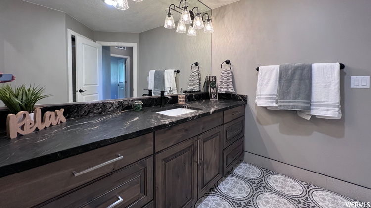 Bathroom with a chandelier and vanity