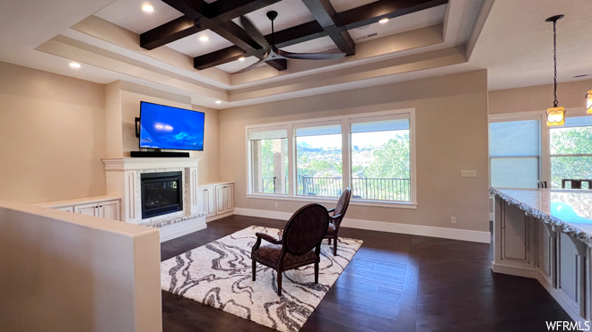 Living room featuring coffered ceiling, ceiling fan, dark hardwood floors, and beamed ceiling