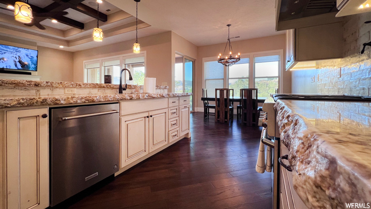 Kitchen featuring dark hardwood flooring, coffered ceiling, pendant lighting, and stainless steel dishwasher