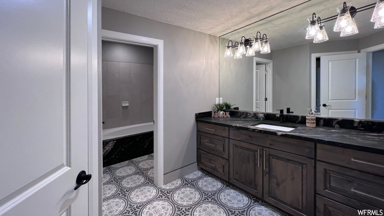 Bathroom featuring vanity, tile floors, and a textured ceiling