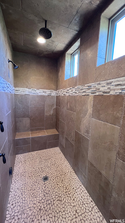 Bathroom featuring a tile shower and a wealth of natural light