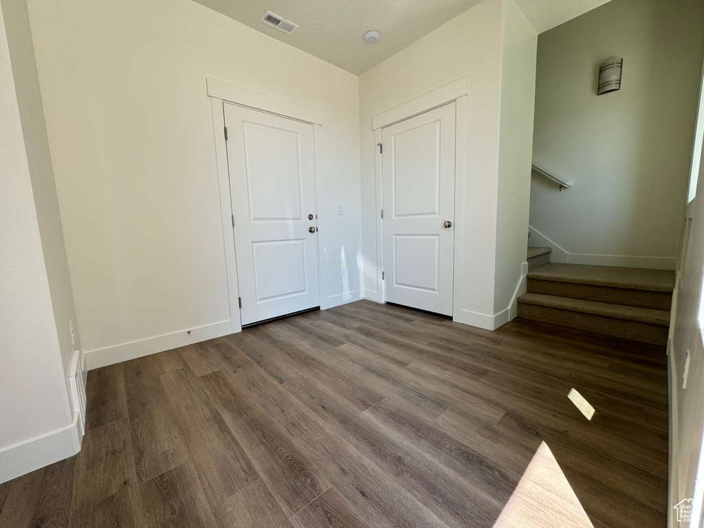 Unfurnished bedroom with a closet and dark hardwood / wood-style flooring