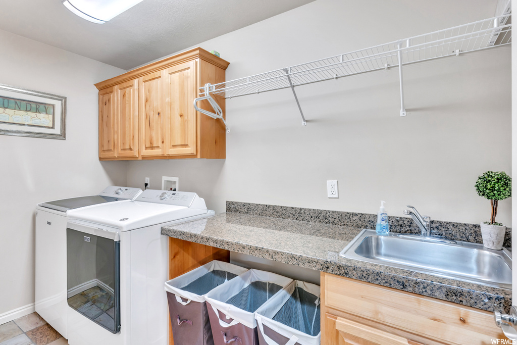 Laundry room featuring independent washer and dryer, cabinets, light tile floors, hookup for a washing machine, and sink