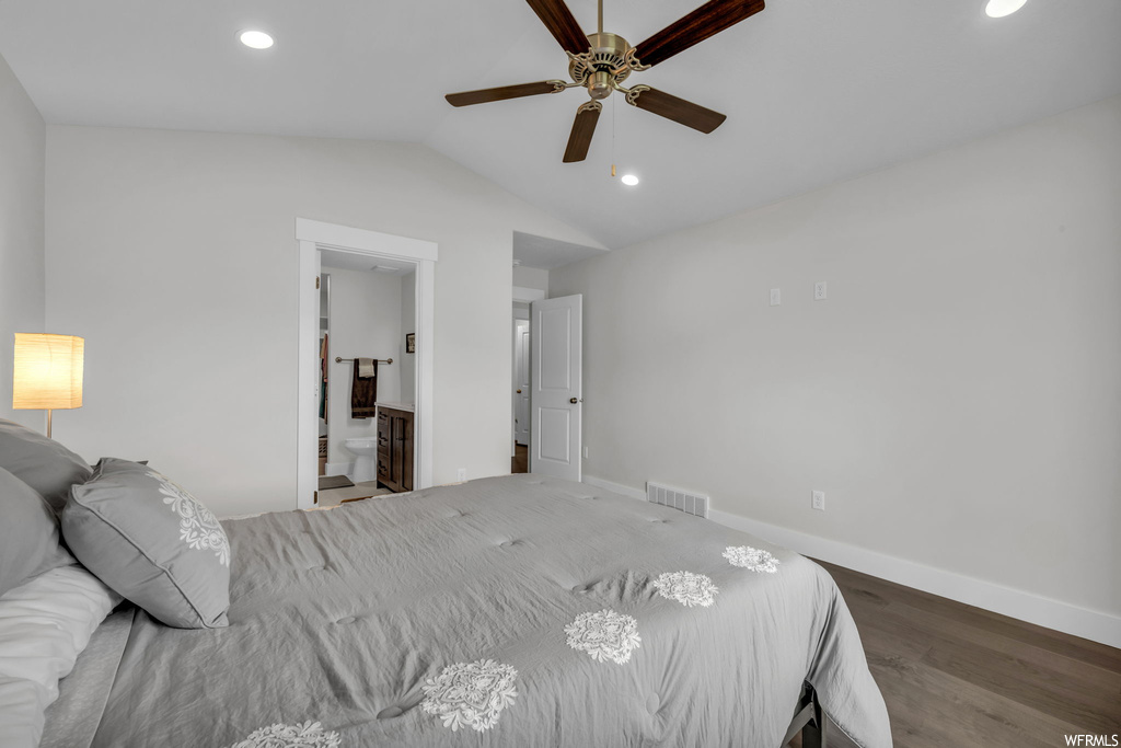 Bedroom featuring connected bathroom, hardwood floors, lofted ceiling, and ceiling fan