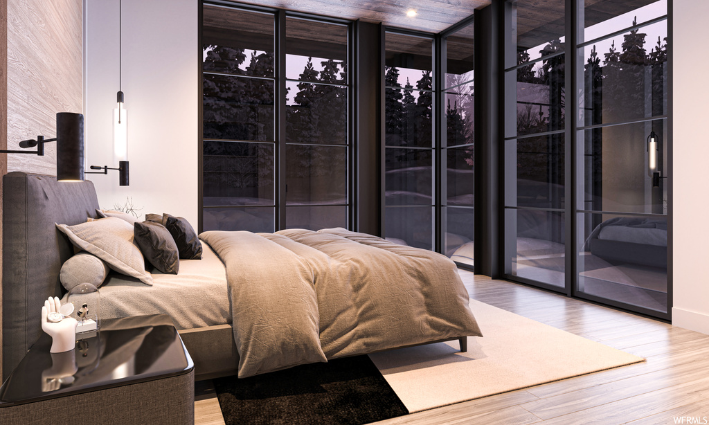 Hardwood floored bedroom featuring expansive windows