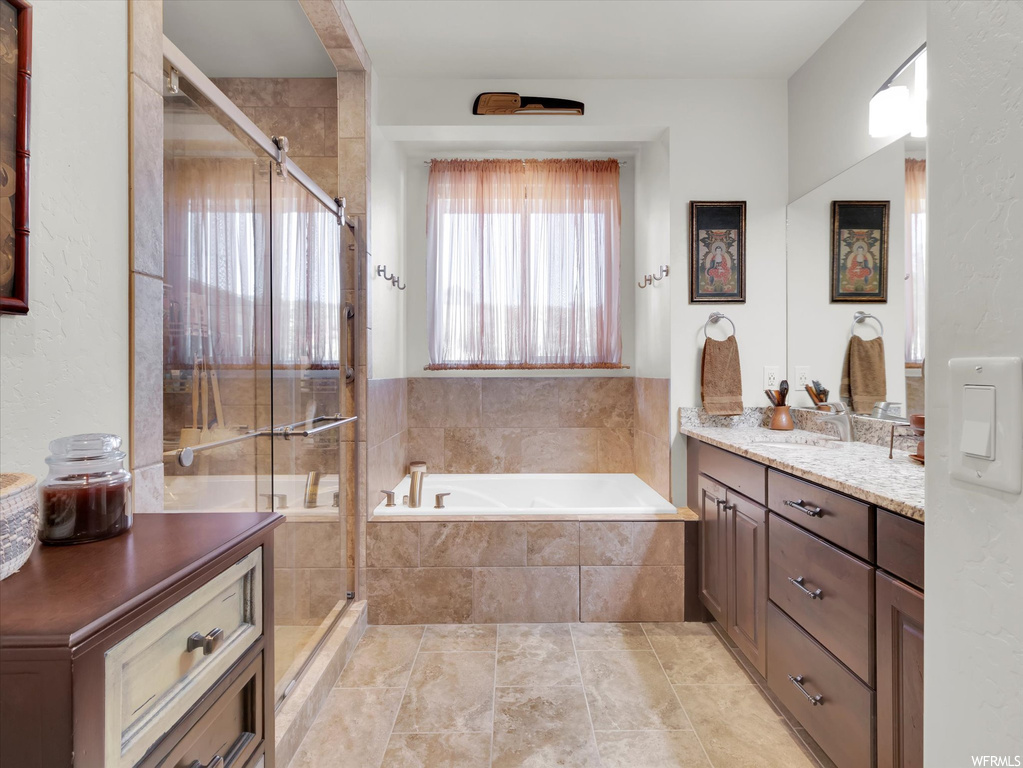 Bathroom with vanity, independent shower and bath, and tile flooring