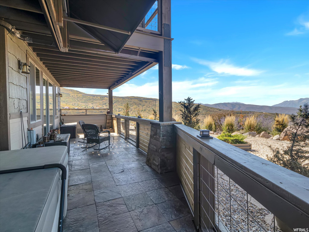 View of patio featuring a balcony and a mountain view