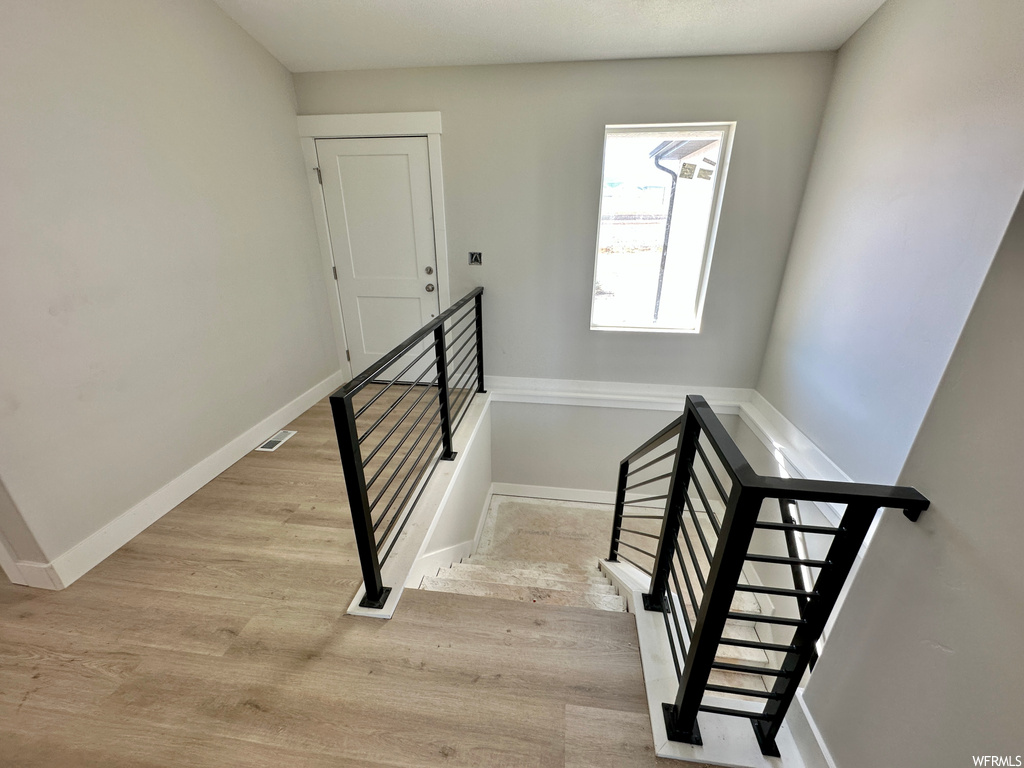 Stairway with light hardwood flooring