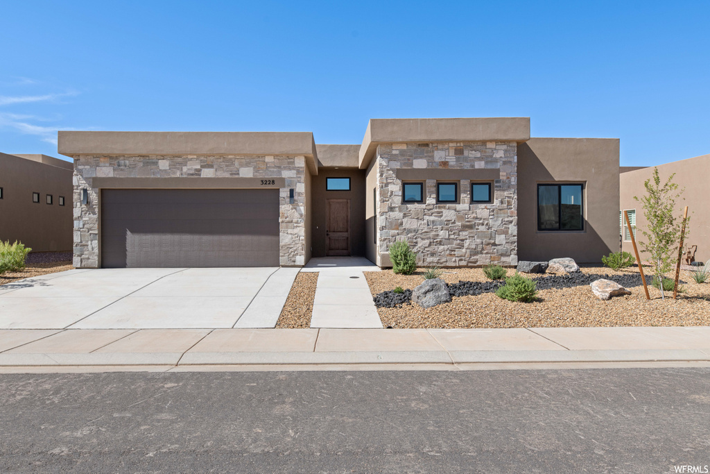 Pueblo revival-style home featuring a garage