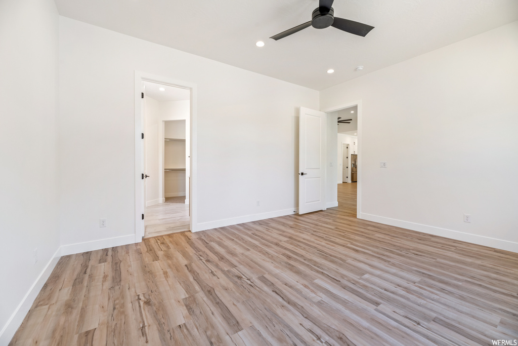 Hardwood floored spare room featuring ceiling fan