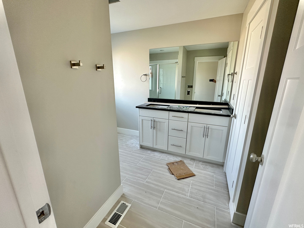 Bathroom with tile flooring and dual vanity