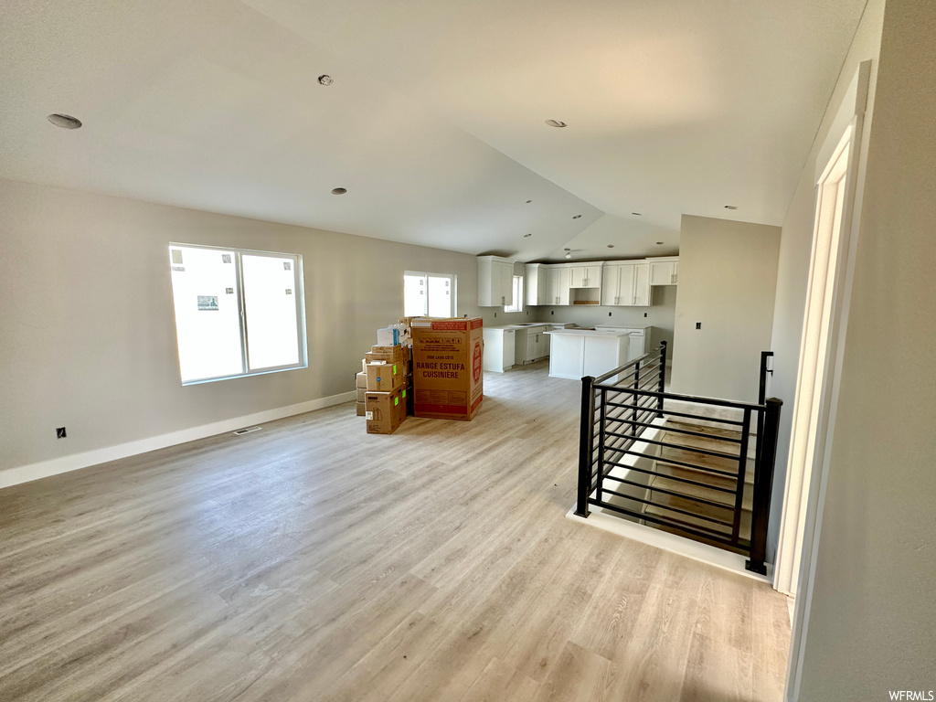 Interior space with light hardwood flooring and lofted ceiling