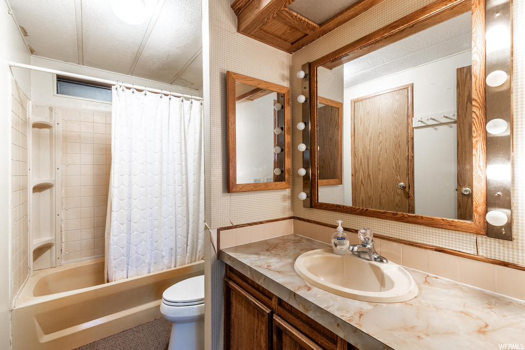 Full bathroom with large vanity, shower / tub combo, and toilet