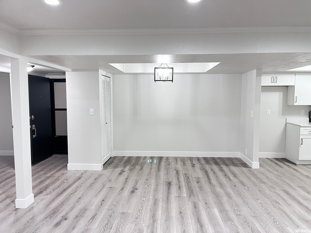 Basement featuring light hardwood flooring and ornamental molding