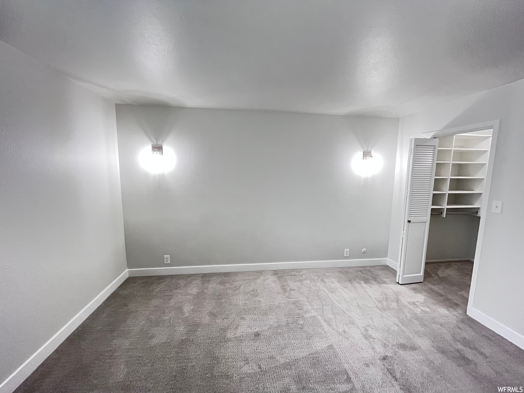 Unfurnished bedroom with carpet floors, a spacious closet, and a closet