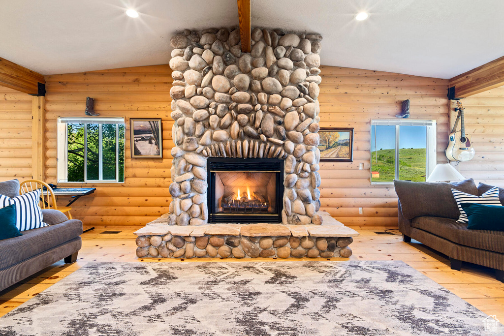 Living room featuring log walls and vaulted ceiling with beams