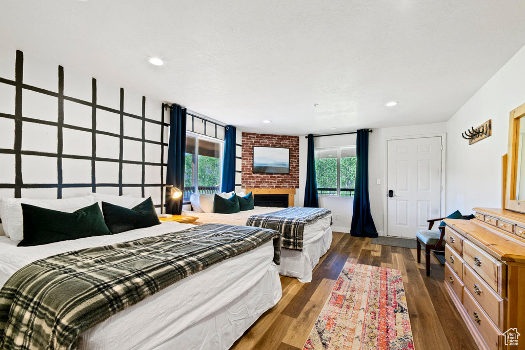 Bedroom featuring dark hardwood / wood-style floors and a fireplace