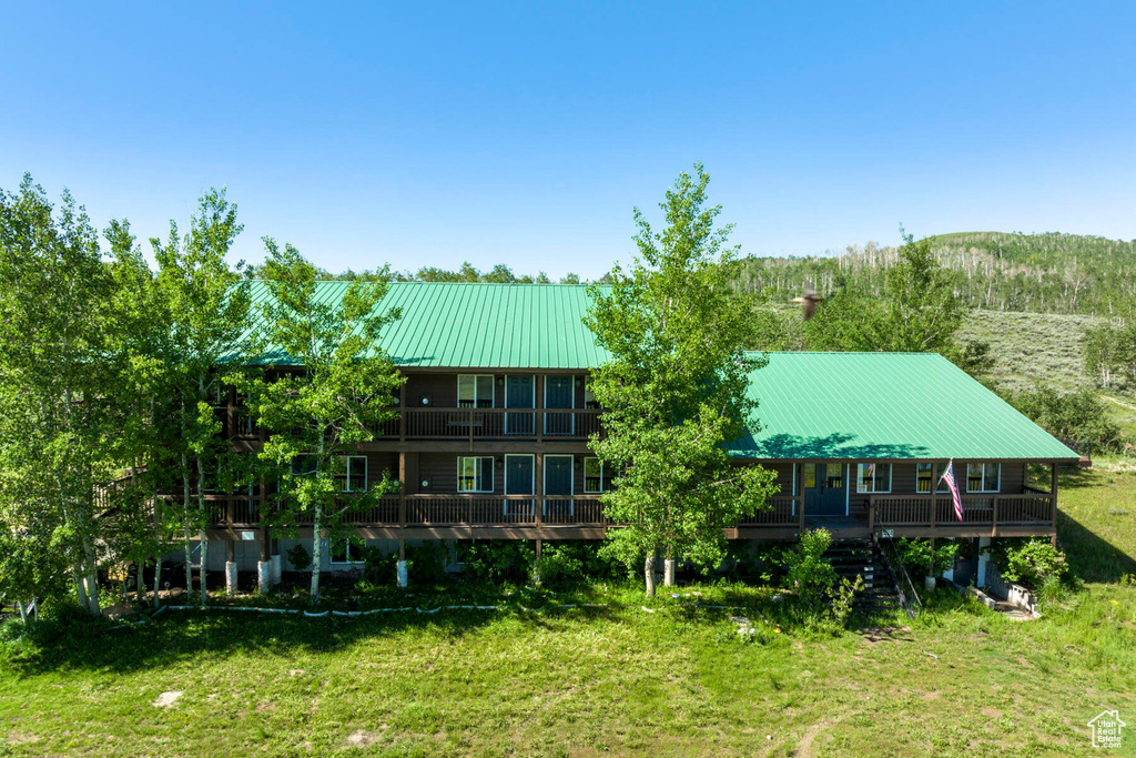 Exterior space featuring a lawn and a wooden deck