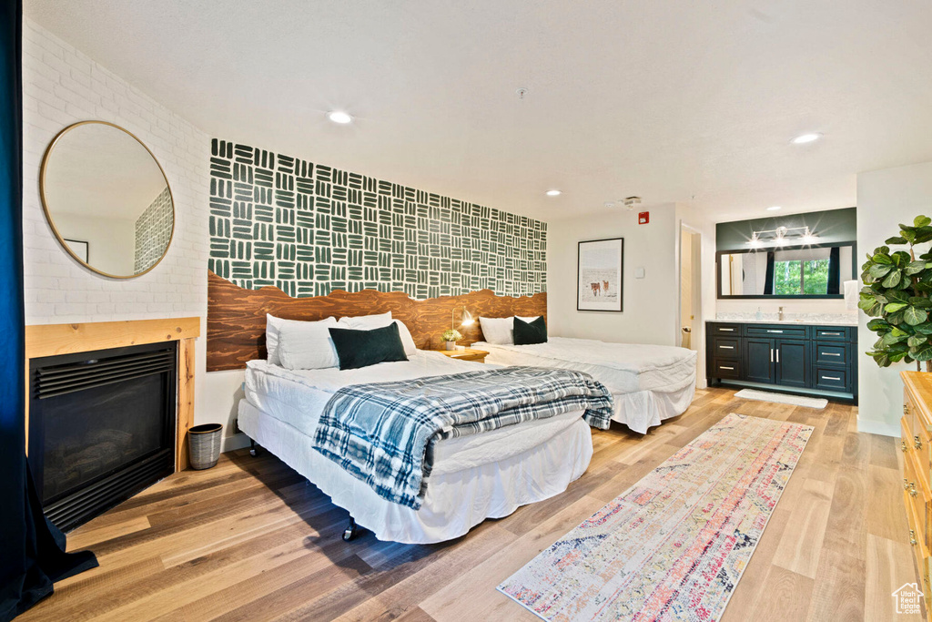 Bedroom featuring light hardwood / wood-style floors and a fireplace