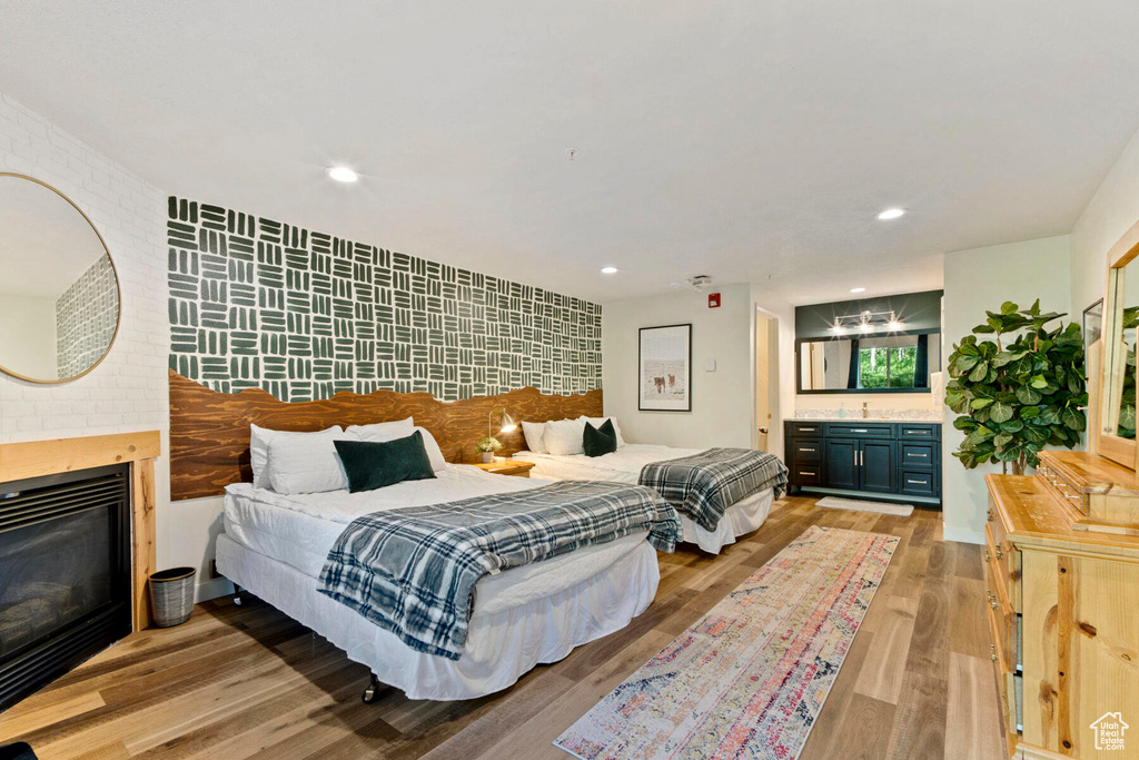 Bedroom featuring sink, light hardwood / wood-style floors, and a fireplace