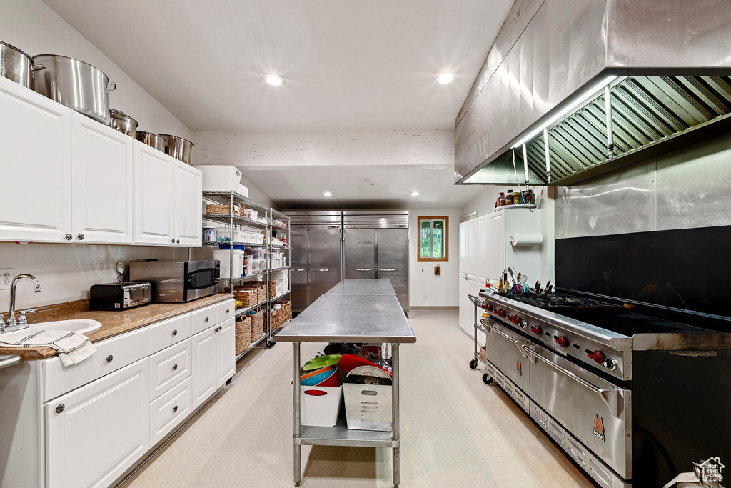Kitchen featuring white cabinets, sink, and appliances with stainless steel finishes