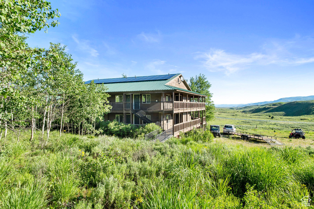Rear view of house with a rural view and a deck with mountain view