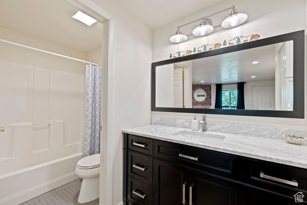 Full bathroom with shower / bath combo, tile patterned flooring, vanity, and toilet