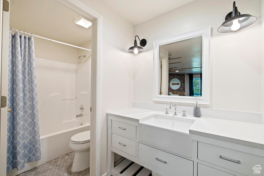 Full bathroom featuring toilet, tile floors, vanity, and shower / tub combo with curtain