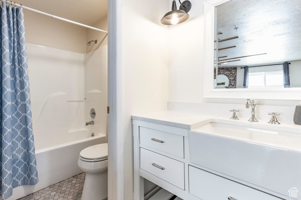 Full bathroom with shower / bath combination with curtain, vanity, a textured ceiling, tile patterned flooring, and toilet