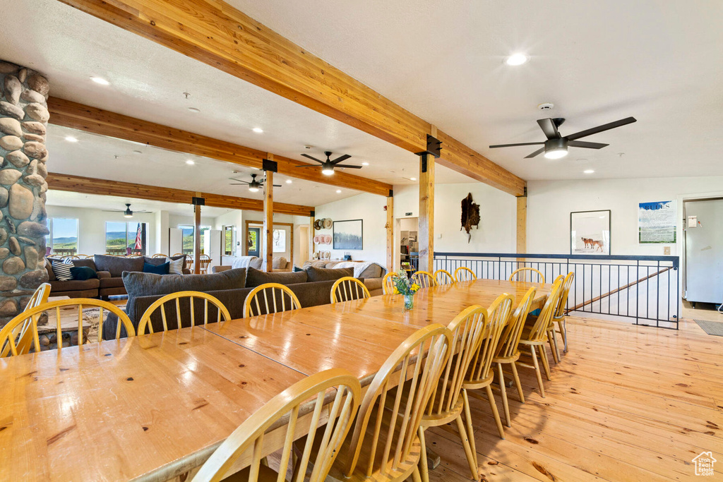 Dining space with beamed ceiling and light hardwood / wood-style flooring