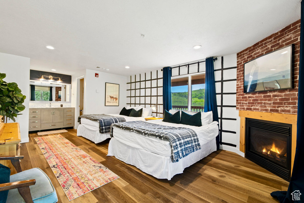 Bedroom with hardwood / wood-style floors and a brick fireplace