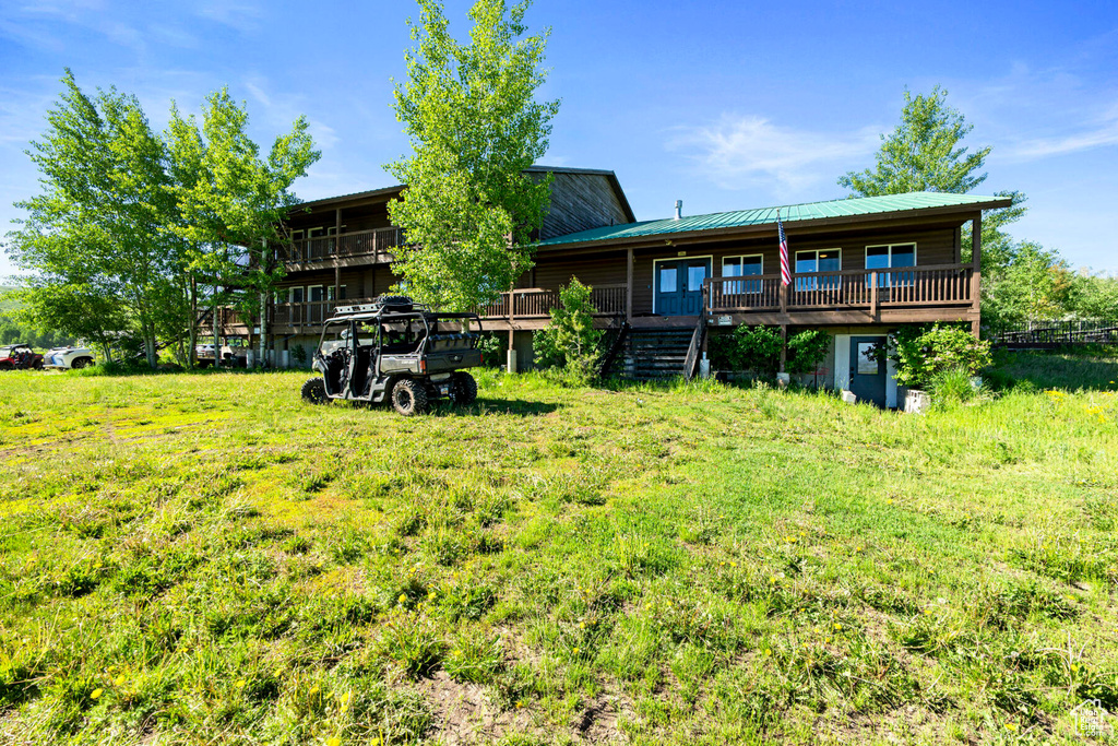 Rear view of property featuring a yard and a deck
