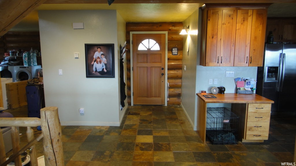Tiled entryway with rustic walls and a fireplace