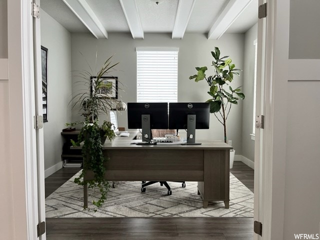 Hardwood floored office featuring beam ceiling