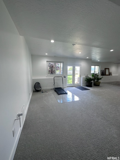 Interior space with a textured ceiling and carpet flooring