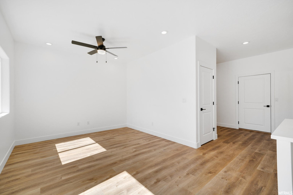 Hardwood floored spare room featuring ceiling fan