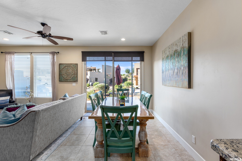Dining area with plenty of natural light, light tile floors, and ceiling fan