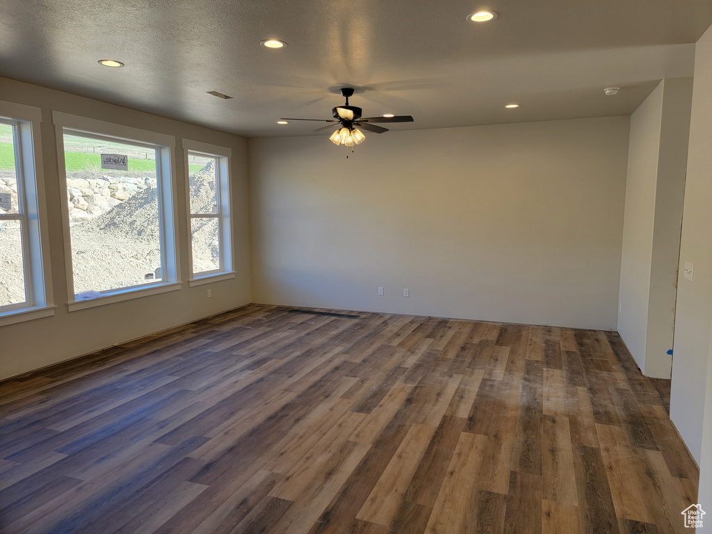 Unfurnished room with a healthy amount of sunlight and dark wood-type flooring